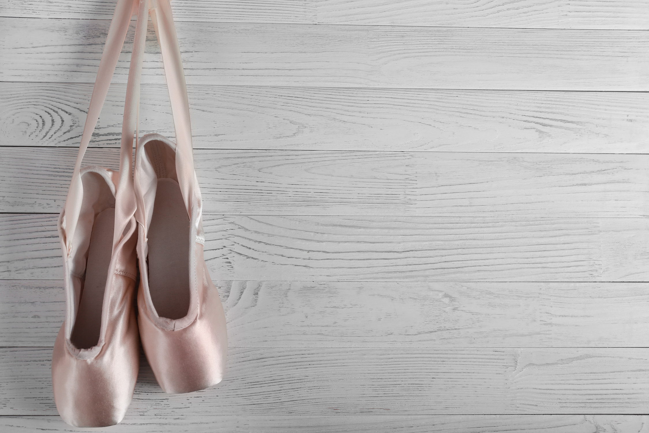 Hanging Ballet Shoes on Wooden Background